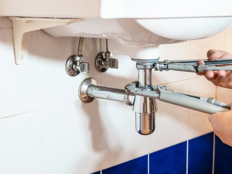 Plumber,Fixes,Sink,Siphon,By,Two,Pipe-wrenches,In,Bathroom